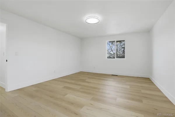an empty room with a painting on the wall