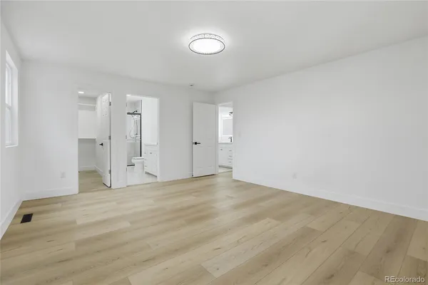 a view of empty room with wooden floor