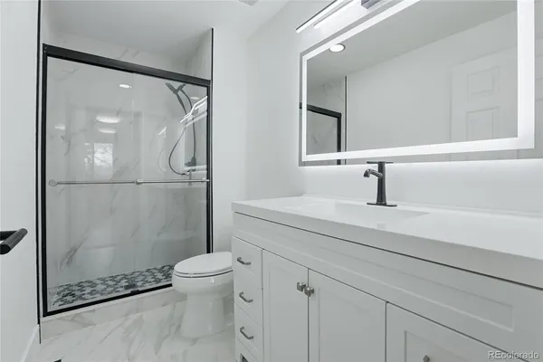 a bathroom with a sink a toilet and shower