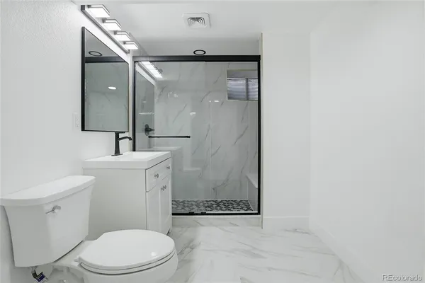 a bathroom with a toilet sink and a mirror