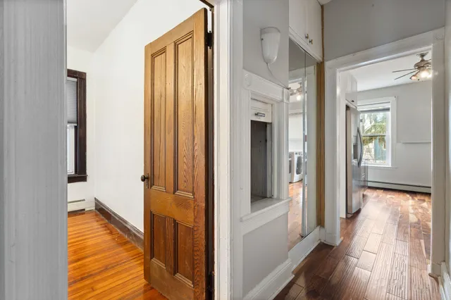 a view of a hallway with wooden floor and staircase