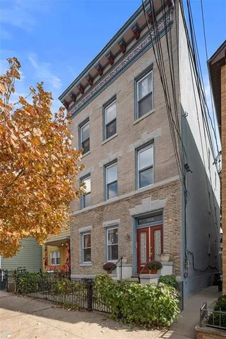 a view of a brick building next to a yard