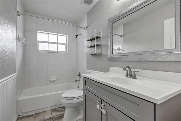 a bathroom with a sink toilet vanity and bathtub