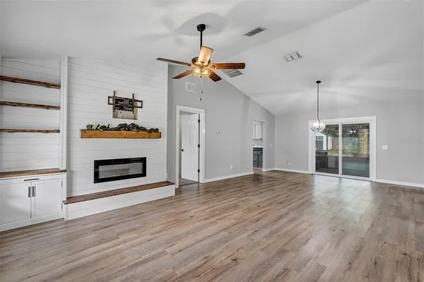 a view of empty room with wooden floor and fireplace