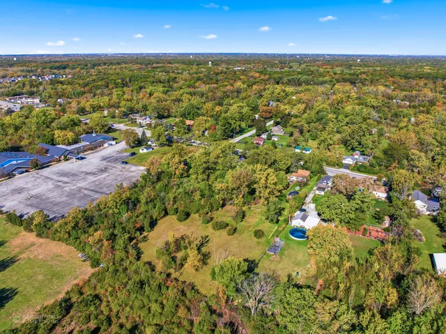 an aerial view of residential houses with outdoor space and trees
