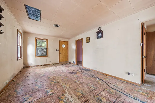 a view of an empty room with window and stairs