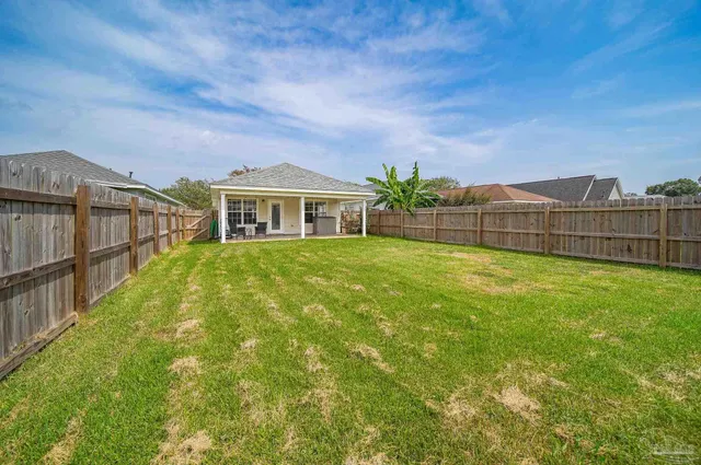 a view of a house with a big yard and sitting area