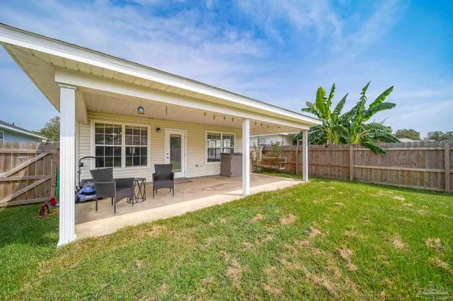 a view of a house with backyard porch and sitting area
