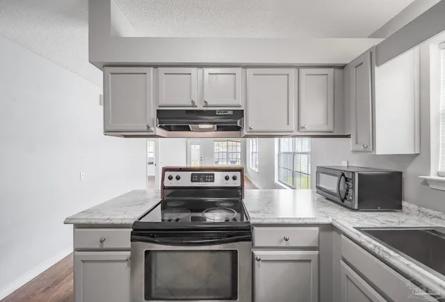 a kitchen with appliances a sink and cabinets