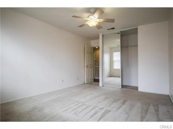 a view of an empty room with a ceiling fan