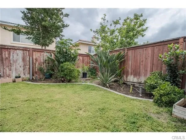 a view of backyard with potted plants and wooden fence