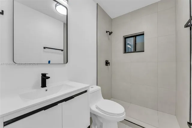 a bathroom with a sink toilet a mirror and shower