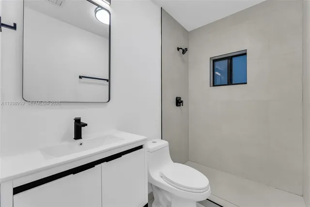 a bathroom with a toilet a sink and mirror