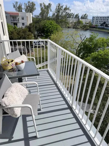 a balcony with wooden floor and lake view
