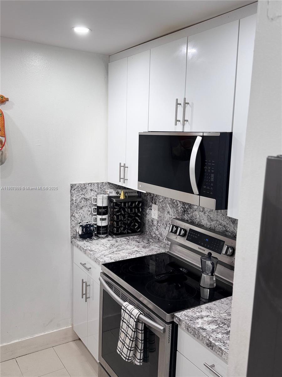 8260 Southwest 210th Street, Unit 310 Cutler Bay, FL 33189 - Photo 5 of 14 a kitchen with a stove and a microwave