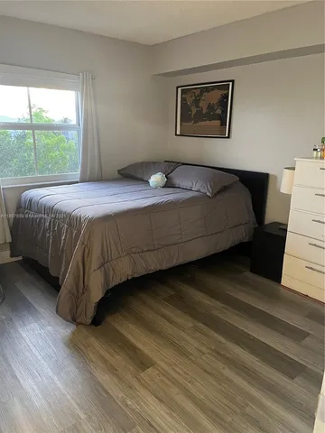 a bedroom with a bed and a large window
