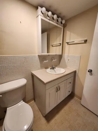 a bathroom with a toilet sink and mirror