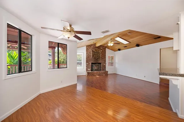 an empty room with wooden floor and fireplace
