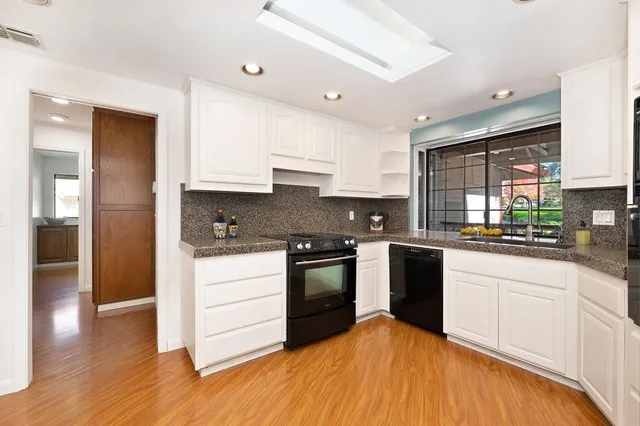 a kitchen with stainless steel appliances granite countertop a refrigerator and a sink