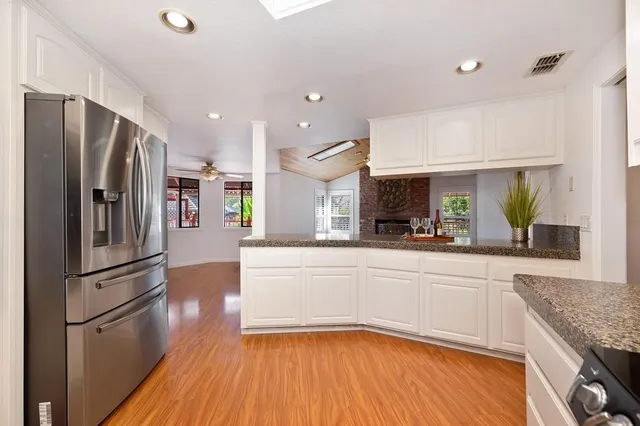 a view of kitchen with granite countertop wooden cabinets and a stove top oven