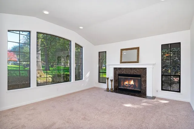 a view of an empty room with a fireplace and a window