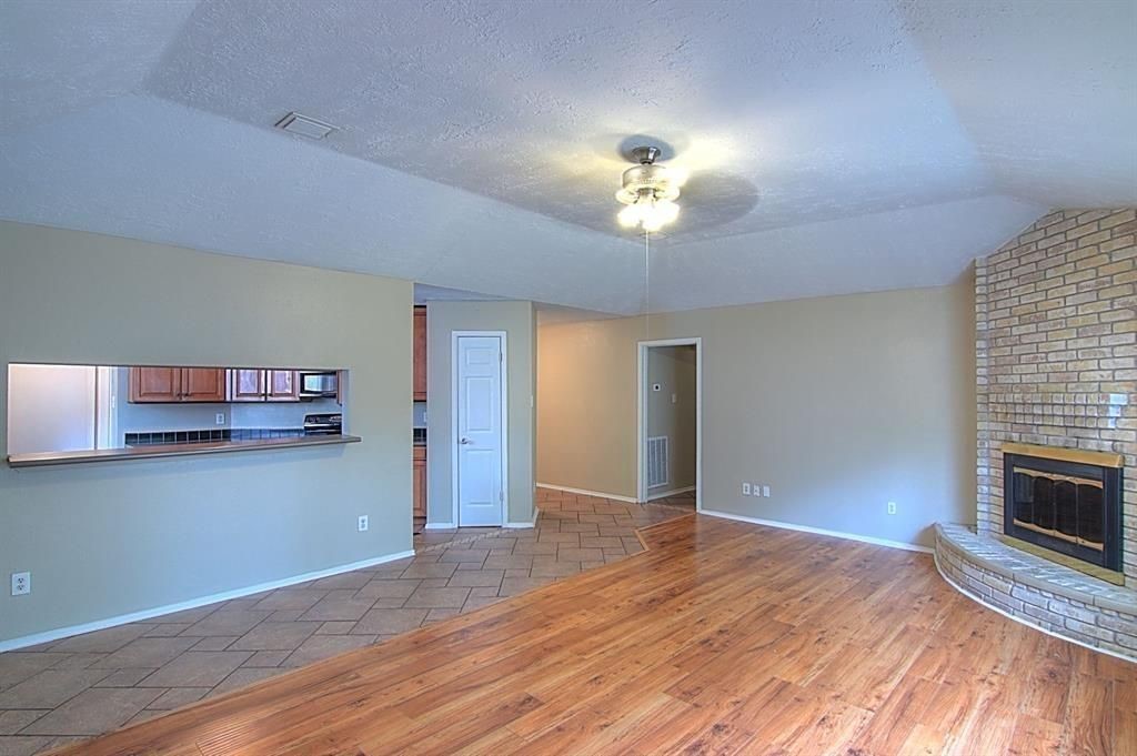 1111 Jack Block Court Crosby, TX 77532 - Photo 3 of 17 a view of a livingroom with a fireplace a ceiling fan and wooden floor