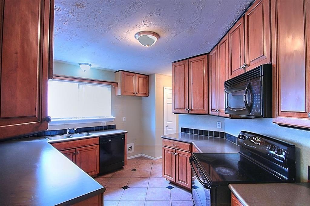 1111 Jack Block Court Crosby, TX 77532 - Photo 5 of 17 a kitchen with granite countertop a stove and a sink