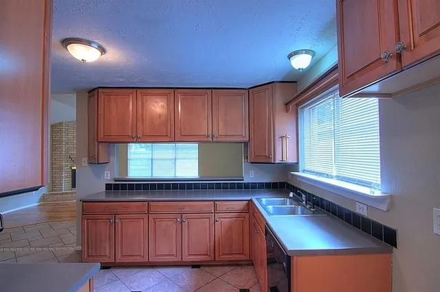 a kitchen with granite countertop sink cabinets and window