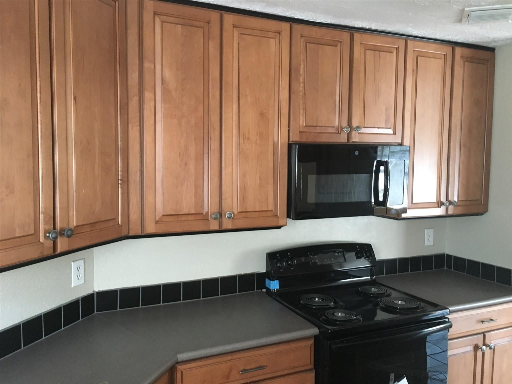 1111 Jack Block Court Crosby, TX 77532 - Photo 7 of 17 a kitchen with granite countertop cabinets and black appliances