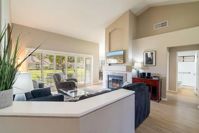 a living room with fireplace furniture and a large window