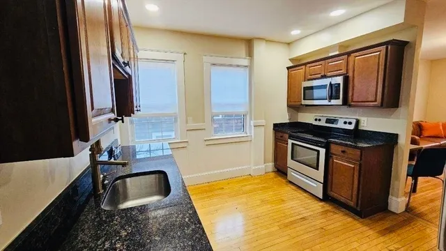 a kitchen with granite countertop a stove and a sink