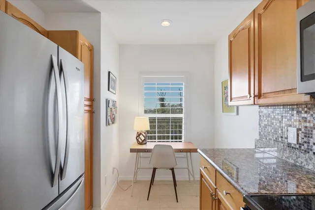 a kitchen with stainless steel appliances granite countertop a sink stove refrigerator and cabinets