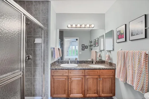 a bathroom with a granite countertop sink and a mirror