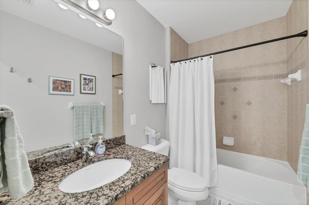 8407 Placida Road, Unit 307 Placida, FL 33946 - Photo 26 of 50 a bathroom with a granite countertop sink toilet a shower and a mirror