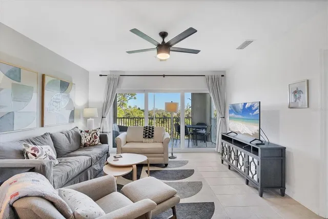 a living room with furniture a flat screen tv and a large window