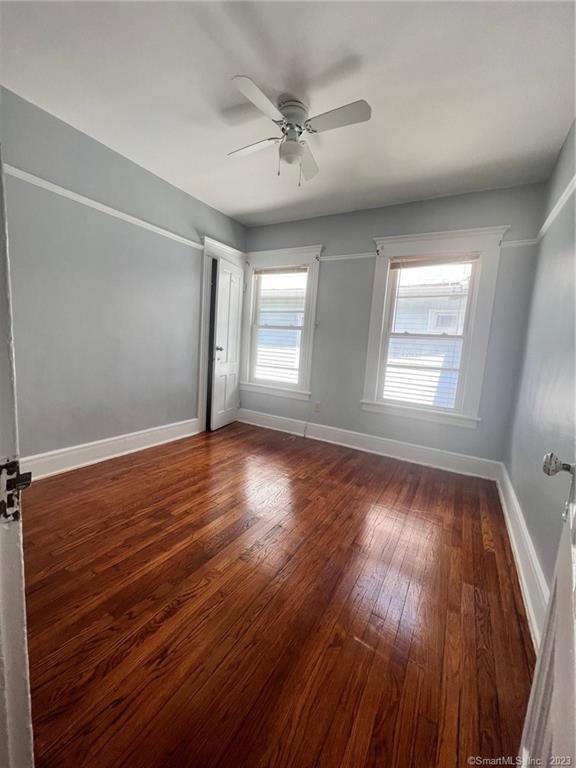 819 William Street, Unit 2 Bridgeport, CT 06608 - Photo 3 of 11 an empty room with wooden floor and windows