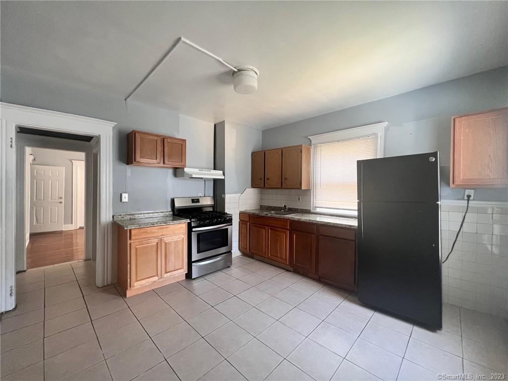 819 William Street, Unit 2 Bridgeport, CT 06608 - Photo 4 of 11 a large kitchen with stainless steel appliances granite countertop a refrigerator and a stove top oven