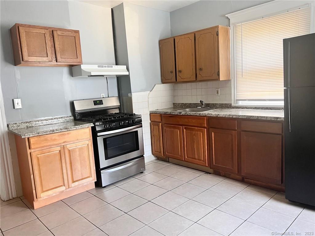 819 William Street, Unit 2 Bridgeport, CT 06608 - Photo 6 of 11 a kitchen with stainless steel appliances granite countertop a stove a sink and a refrigerator