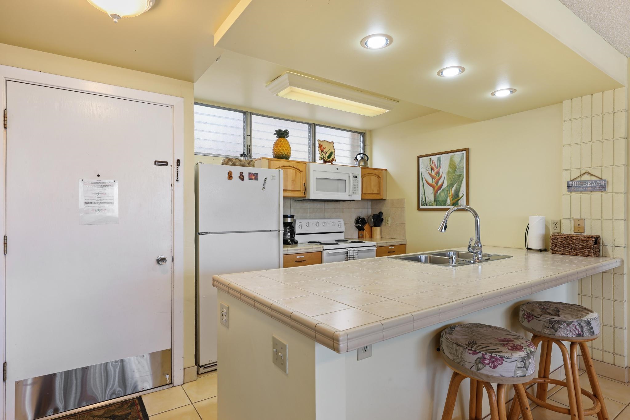 2619 South Kihei Road, Unit A305 Kihei, HI 96753 - Photo 2 of 44 a kitchen with stainless steel appliances a sink a stove a refrigerator and cabinets