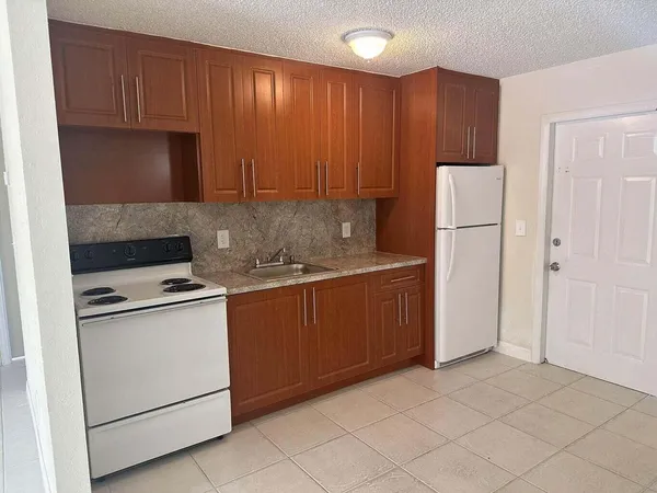 a kitchen with a sink a stove and a refrigerator
