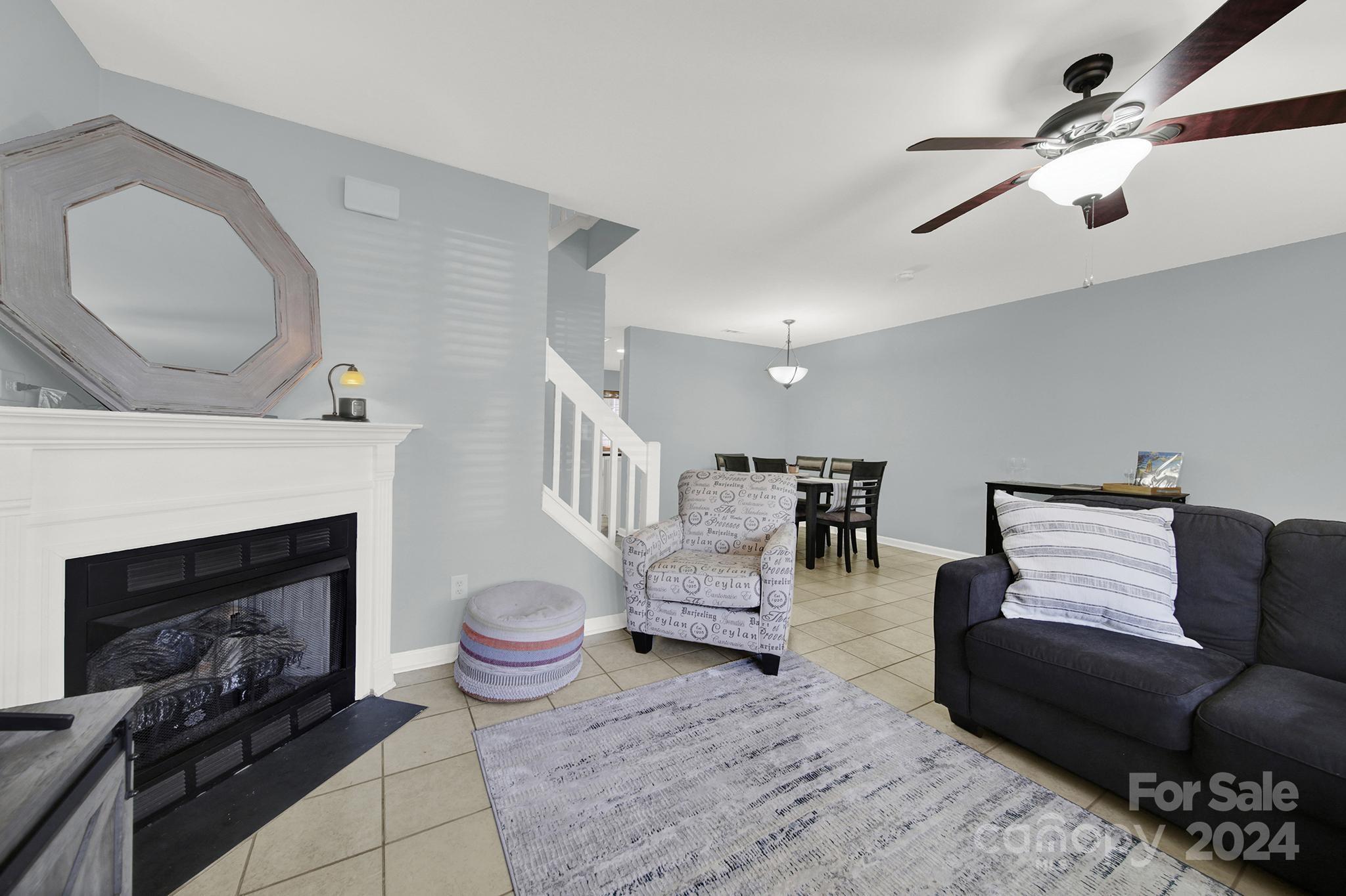8134 Rudolph Road Charlotte, NC 28216 - Photo 11 of 27 a living room with furniture a fireplace and a ceiling fan