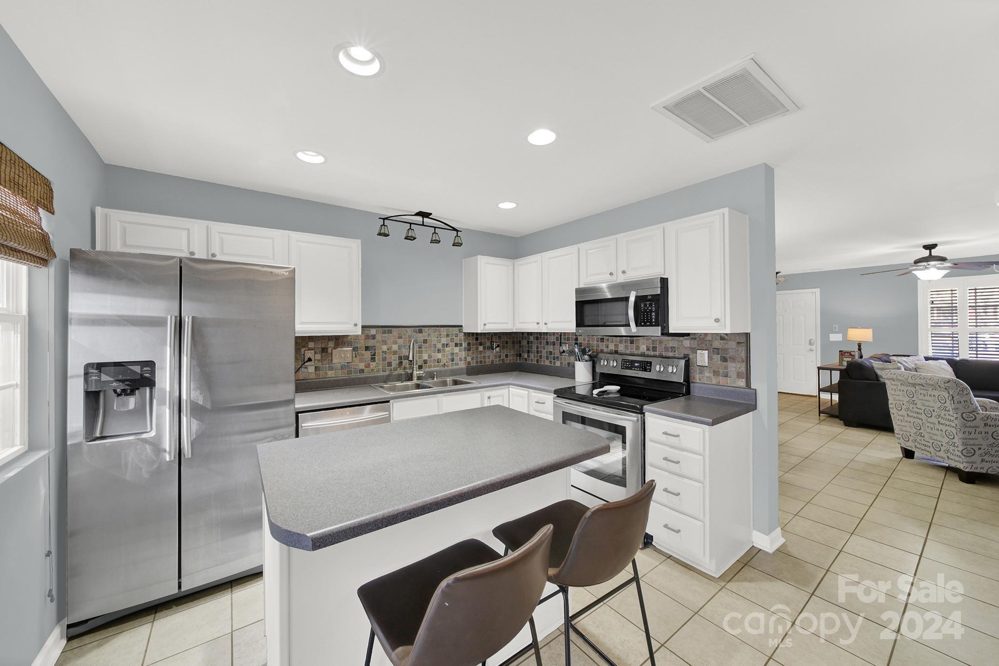 8134 Rudolph Road Charlotte, NC 28216 - Photo 14 of 27 a kitchen with stainless steel appliances granite countertop a refrigerator and a stove top oven
