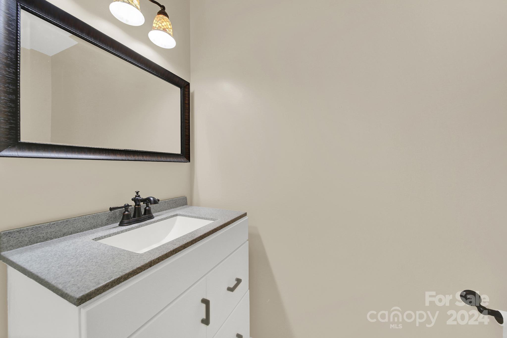 8134 Rudolph Road Charlotte, NC 28216 - Photo 17 of 27 a bathroom with a sink vanity and a mirror