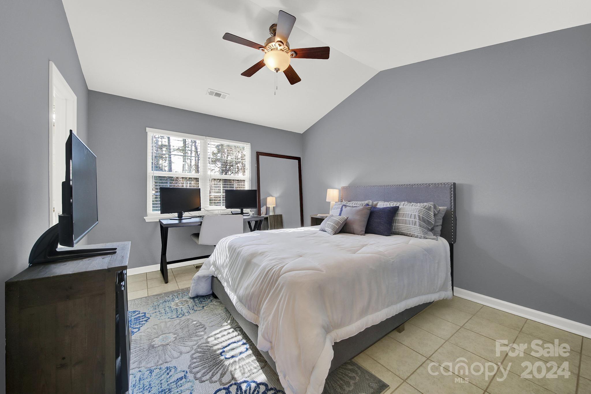 8134 Rudolph Road Charlotte, NC 28216 - Photo 23 of 27 a bedroom with a large bed and a flat screen tv