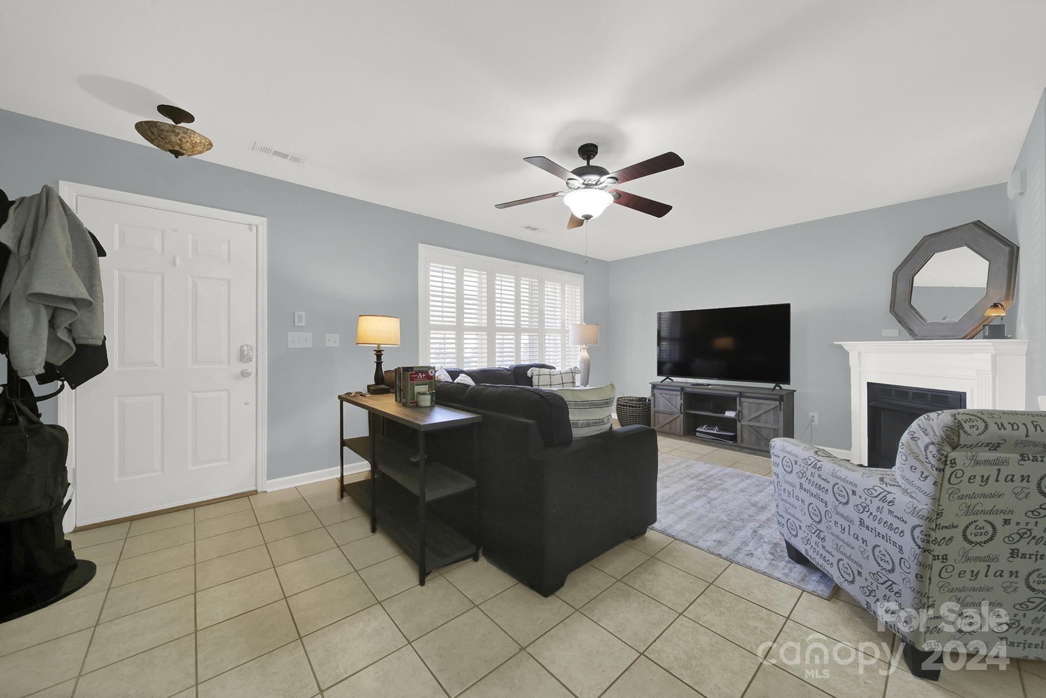 8134 Rudolph Road Charlotte, NC 28216 - Photo 9 of 27 a living room with furniture a flat screen tv and a fireplace