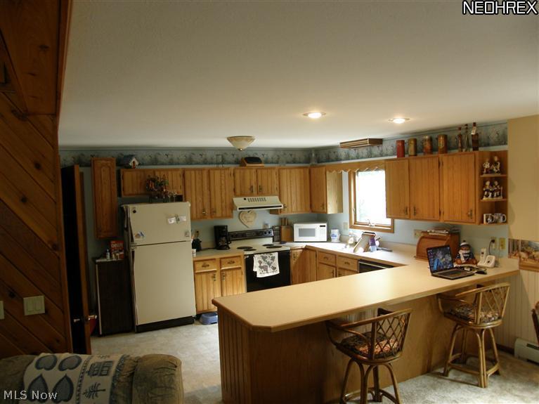 16353 Moseley Road Thompson, OH 44086 - Photo 6 of 20 Large kitchen with plenty of cabinets and counter space. Door leading to basement. First floor laundry!!