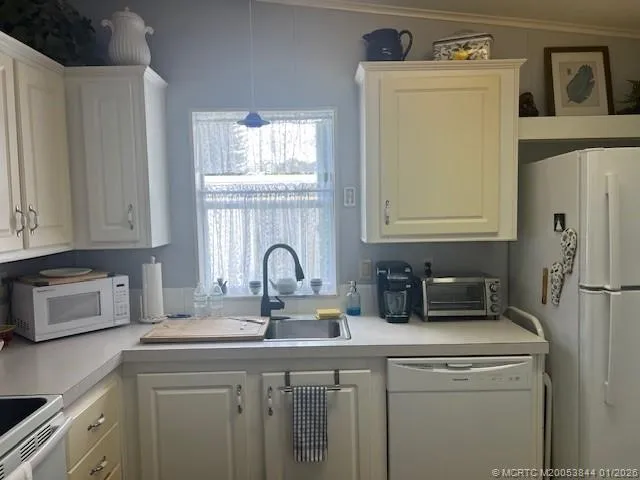 a kitchen with granite countertop white cabinets and white appliances