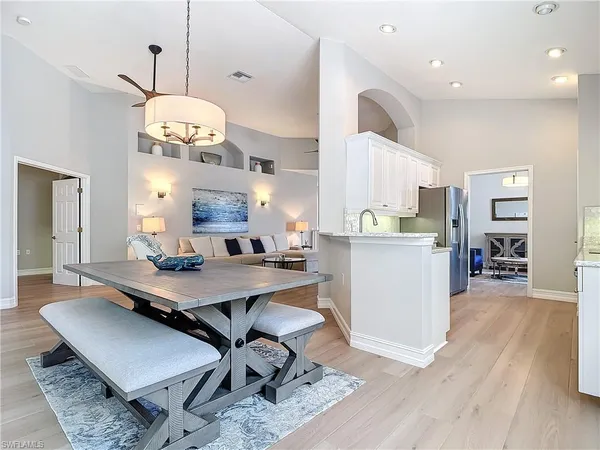 a room with stainless steel appliances kitchen island granite countertop furniture wooden floor and a view of kitchen