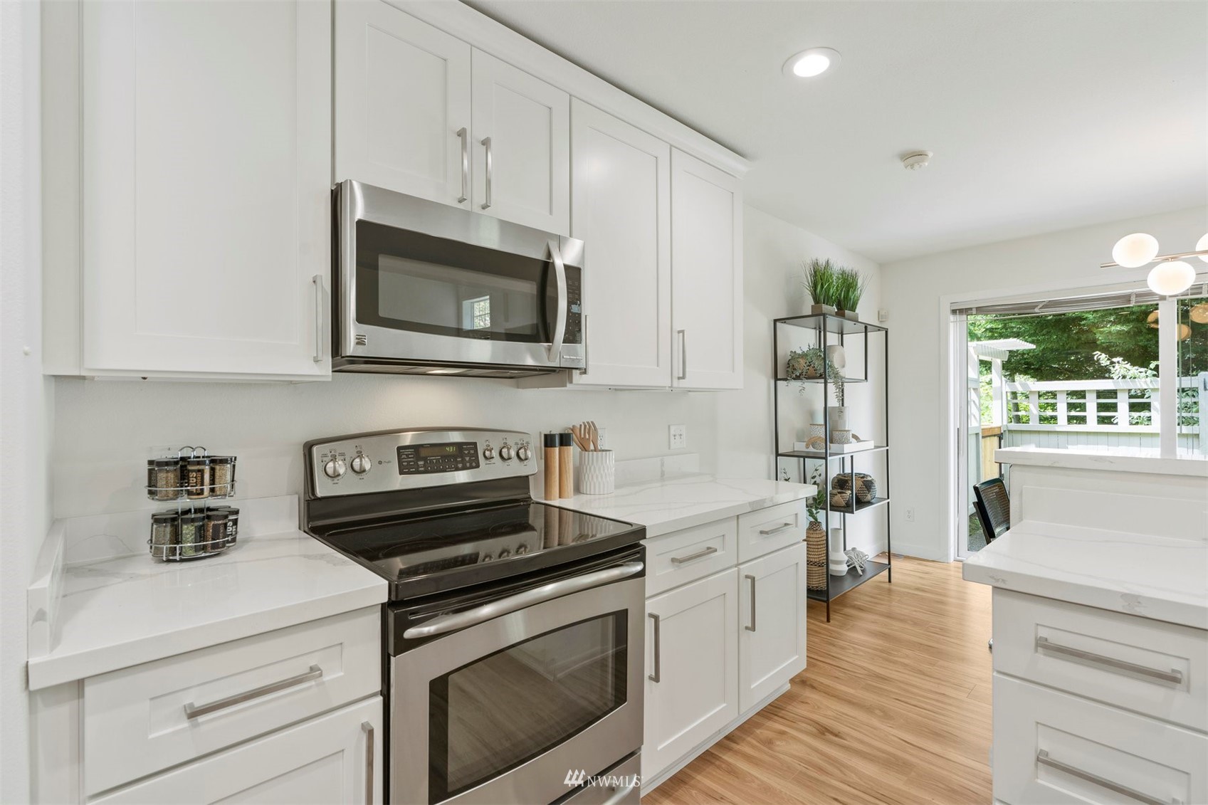 507 Elma Place Northeast Renton, WA 98059 - Photo 20 of 36 a kitchen with stainless steel appliances white cabinets and a stove a oven with wooden floor