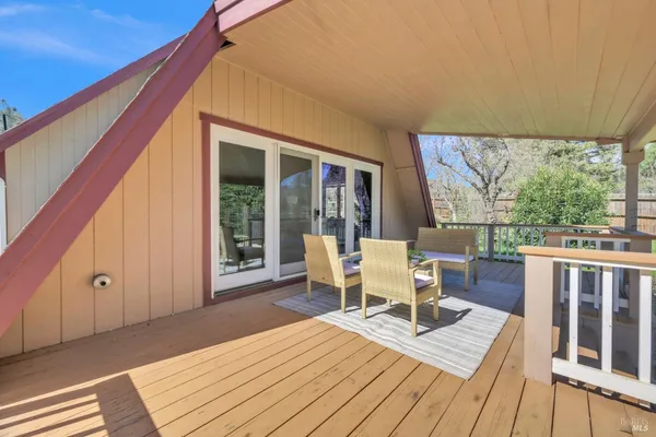 a balcony with wooden floor table and chairs